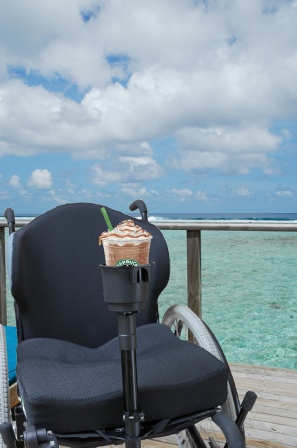 Photo of wheelchair with drink holder on balcony overlooking the ocean